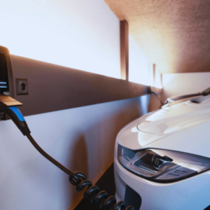 Coche eléctrico cargando en un punto de recarga de un garaje comunitario