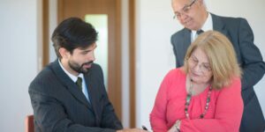 Matrimonio mayor firmando con su abogado los documentos de una propiedad heredada